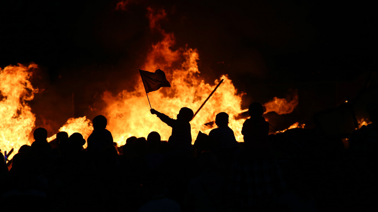 A child in front of a fire raising a flag - Dhillon Law Group